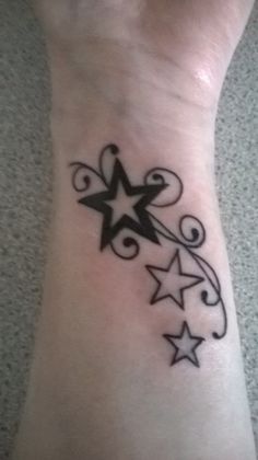 a small star tattoo on the ankle with swirls and stars around it's center