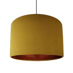 a yellow lamp hanging from a ceiling with a brown shade on it's side