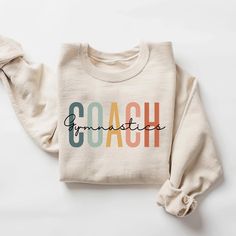 Gymnastics Coach Sweatshirt, Gymnastics Coach Shirt, Gymnastics Coach Gift, Gymnast Coach Crewneck Sweatshirt Unisex How to Order 1* View all color and size charts before you place your order. 2* Select your shirt "SIZE" and "COLOR". 3* Click add to cart.  If you are ordering more than 1 item, you need to repeat this process for each item you wish to order. Product Information Gildan Hoodie- Sweatshirt 8 oz.(US) 13.3 oz.(CA), 50/50 preshrunk cotton/polyester Heather Sport colors: 60/40 polyester/cotton Air jet yarn = softer feel and reduced pilling Double needle stitching at shoulder, armhole, neck, waistband and cuffs 1 x 1 rib with spandex Quarter-turned to eliminate center crease Safety Green: Compliant with ANSI / ISEA 107 Tearaway label Washing Care Instructors Use cold water when was Multicolor Cotton Sports Sweatshirt, Multicolor Crew Neck Sweatshirt For Sports, Cotton Workout Sweatshirt With Letter Print, Cotton Sweatshirt With Letter Print For Workout, Coach Sweatshirt, Gymnastics Coach, Coach Shirt, Gymnastics Coaching, Coach Shirts