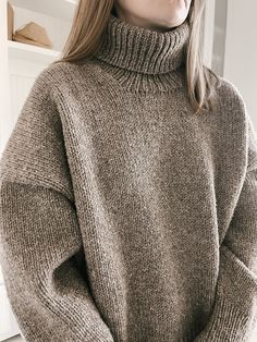 a woman wearing a brown turtle neck sweater