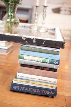 a stack of books sitting on top of a wooden table