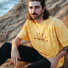 Feel the magic of golden hour whenever you rock this tee! Inspired by sunsets on our California coastline, this t-shirt reflects the sparkling colors of golden hour on the ocean. Our original "Golden" graphic is hand printed on the chest, and our retro logo is printed on the sleeve. Made with recycled cotton fabric by our team in Los Angeles. Gold T-shirt With Letter Print For Summer, Casual Gold T-shirt For Summer, California Coastline, On The Ocean, Retro Logo, You Rock, Golden Hour, Recycled Cotton, The Ocean