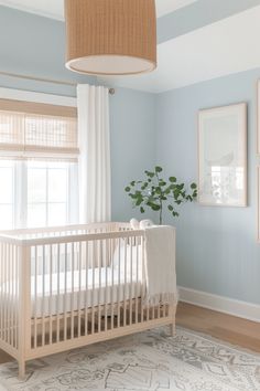 a baby's room with blue walls and white furniture