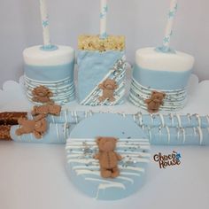 blue and white baby shower cake with teddy bears on the top, candles in the middle