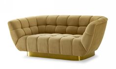 a beige couch with gold legs and a curved back, sitting in front of a white background