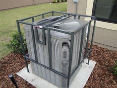 an air conditioner sitting on top of a cement slab in front of a house