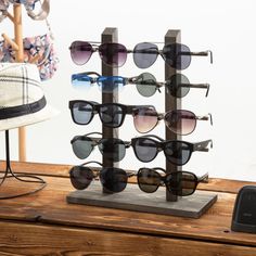 sunglasses are on display in front of a hat rack