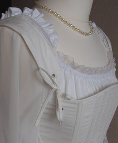 For the 18th century silhouette, I propose a corset to wear on your day shirt. An essential element of any outfit of the 18th century, this corset is made in 2 versions: - Cotton striped white and blue, lined in white cotton. - Cotton white, lined in white cotton White lacing link. Like any corset of the ladies of the bourgeoisie or of the nobility, it is laced only in the back. The servants and peasants only, wore corsets laced at the front, for they had no one to help them dress. Knotted at th Elegant Historical Design Corset For Costume Party, White Fitted Bodice Corset For Costume, White Underbust Corset For Costume, Elegant Corset With Historical Design For Costume Party, Victorian White Underbust Corset, White Historical Design Corset For Wedding, Historical Design White Wedding Corset, White Victorian Overbust Corset, Wedding Regency Style Underbust Corset