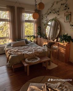 a bed room with a neatly made bed next to two windows and a cat laying on the floor