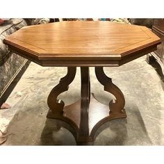 a wooden table sitting on top of a floor next to a couch in a room