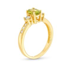 You'll adore the vibrant color and sophisticated sparkle of this oval-shaped green peridot and diamond three-stone ring in 14K gold. Created in 14K gold The 7.0 x 5.0mm oval-shaped spring-green peridot glistens between a pair of shimmering 1/15 ct. round diamonds. Dainty channel-set diamonds adorn the shank to complete the design. This ring shines with 1/4 ct. t.w. of diamonds. Yellow Gold Three-stone Oval Birthstone Ring, Yellow Gold Three Stone Oval Birthstone Ring, Diamond Three Stone Ring, Three Stone Ring, Green Peridot, Channel Set, Three Stone Rings, Spring Green, Three Stone