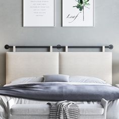 a bed with two pictures hanging above it