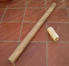 a roll of toilet paper sitting on top of a tiled floor