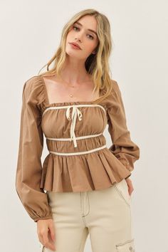 Go ahead, treat yourself to the charming Kate Babydoll Top! With long balloon sleeves, a playful ruffled hem, and a front bow detail, this top is the perfect combination of sweet and chic. The contrast design adds a touch of uniqueness to this taupe-colored top. Details + Fit 100% Cotton Runs True to Size Machine Wash Cold Hang Dry Square neckline Long Balloon Sleeves Elastic Cuffs Front Bow Tie Ruffled Hem Contrast Detail Taupe | Cream | Solid Model is 5'10" and wearing a size Small Contrast Design, Long Balloons, Babydoll Top, Go Ahead, Balloon Sleeves, Bow Detail, Square Neckline, Ruffle Hem, Bow Tie