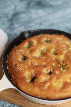 a skillet filled with food sitting on top of a wooden cutting board