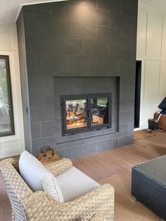 a living room filled with furniture and a fire place in the middle of a wall