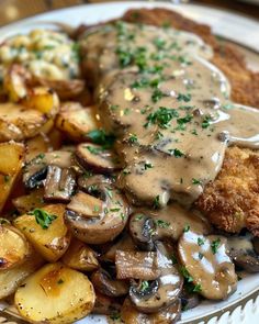 a white plate topped with meat, potatoes and gravy