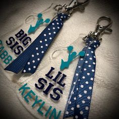 two blue and white polka dot ties are hanging from keychains with the words, sis sis kekin on them