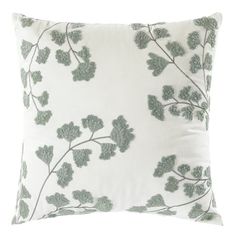 a white pillow with green leaves on it