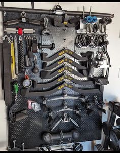 there are many tools hanging on the pegboard in this garage storage area, including wrenches, screwdrives and pliers