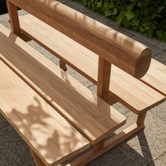 a wooden bench sitting on top of a sidewalk