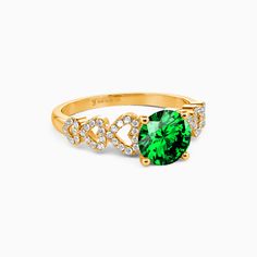 a gold ring with green and white stones