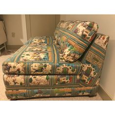 a blue and white couch sitting on top of a carpeted floor next to a wall