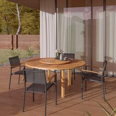 a wooden table sitting on top of a hard wood floored patio next to a sliding glass door