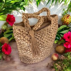 a straw bag sitting on top of a wooden table next to flowers and other plants