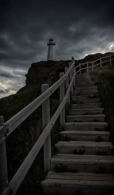 stairs leading up to a lighthouse under a cloudy sky