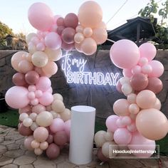 a bunch of balloons that are in front of a sign