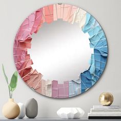 there is a mirror that has many colors in the frame and it is on top of a table