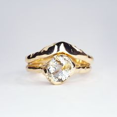 a gold ring with a white diamond in the center and two black bands around it