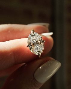 a close up of a person holding a ring with a diamond in it's middle