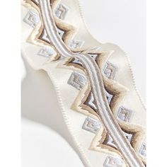 a close up of a white and silver tie on a white background with an intricate design