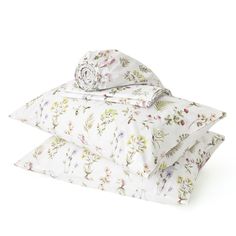 three pillows stacked on top of each other with floral designs in white and pink colors