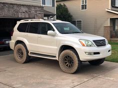 a white suv parked in front of a house