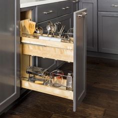 an open cabinet in a kitchen with pots and pans