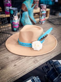 Turquoise Sahara - Camel Fedora Hat Introducing our Turquoise Sahara - Camel Fedora Hat, a regal piece put together by Bronco Western Supply. This Camel Fedora features a stunning Turquoise velvet ribbon hat band that elevates its charisma. Embellished with a rose gold chain and a beautiful cream rose, the hat captures the spirit of the wild west in an elegant way. Also included are bright turquoise and natural colored pheasant feathers that add a dash of rustic, vintage charm to the overall loo Turquoise Wide Brim Hat For Kentucky Derby, Turquoise Curved Brim Hat For Country Events, Turquoise Fedora Hat For Western-themed Events, Turquoise Fedora For Western-themed Events, Turquoise Hat For Kentucky Derby, Turquoise Hat For Kentucky Derby Festival, Turquoise Hat For Festival And Kentucky Derby, Turquoise Hats For Kentucky Derby And Festivals, Turquoise Hat For Kentucky Derby And Country Events