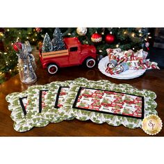 four placemats on a table next to a christmas tree and toy truck in the background