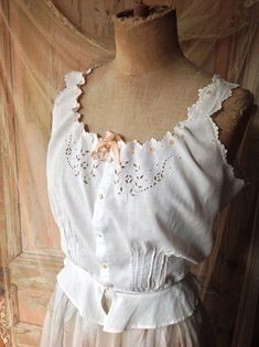 vintage cotton camisole with eyelet lace and scalloped edges. The silk ribbon has a salmon pink color. Bust 92 cm 36"   waist  59 cm  2 1/4" Delicate Lace Trim Camisole For Daywear, Delicate Summer Daywear Camisole, Vintage Lace Trim Camisole For Spring, Elegant Cotton Camisole With Lace Trim, Vintage Lace Camisole For Spring, Delicate Sleeveless Daywear Tops, Vintage Tops With Lace Trim And Spaghetti Straps, Cotton Sleeveless Camisole With Delicate Lace, Sleeveless Cotton Camisole With Lace