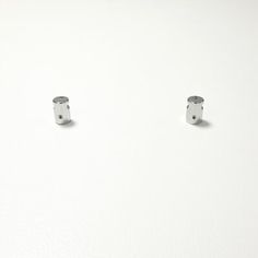 two silver rings sitting on top of a white surface