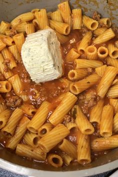 a pot filled with pasta and sauce on top of a stove