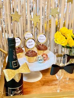 cupcakes and champagne are sitting on a table