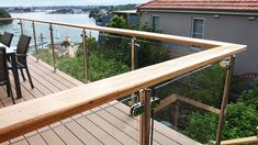 an outdoor deck with table and chairs overlooking the water