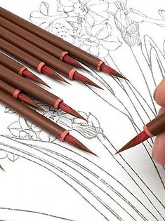 a person is drawing flowers with colored pencils