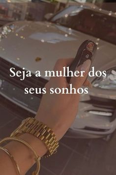 a hand holding a cell phone in front of a car with the words seja a mulher dos seus sonhos