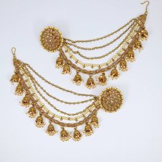 This luxurious Antique Gold Kundan polki, pearl and Jhumka detail ear chanin with matching detachable stud earrings. Add this to any earrings and hook into the hair to add extra drama. This Jhumki is ultimate in versatile  Indian jewellery. Approximate earring length 3cm × 3.5cm Ear chain lenght 16cm This gorgeous pair is made on brass as base metal and handcrafted to perfection with studded white beads, Kundan stones, and blush onyx beads. you don't have to opt for the minimalistic all the time. Sometimes it's better to go OTT. Earring Chains, Bahubali Earrings, Ear Chain, Heavy Earrings, Traditional Earrings, Luxury Earrings, Bollywood Jewelry, Indian Wedding Jewelry, Indian Earrings