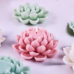 there is a candle in the middle of some fake flowers on the table with it's reflection