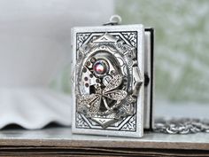 Vintage jeweled watch movement sets on custom silver plated over brass locket and it hangs on 18 inch surgical steel chain with lobster clasp. Measurement, Locket is about 1.4 inch (35mm) in length and 1.1 inch (27mm) in width on 18 inch chain. If you have a preferred length for the chain, please let me know in message to seller box and I will adjust it before shipping. Steampunk Locket Jewelry Collectible, Steampunk Metal Jewelry Engraved, Steampunk Engraved Metal Jewelry, Steampunk Round Locket Jewelry, Vintage Silver Stainless Steel Necklaces, Vintage Silver Stainless Steel Necklace, Steampunk Silver Engraved Jewelry, Steampunk Silver Round Pendant Jewelry, Silver Steampunk Round Pendant Jewelry